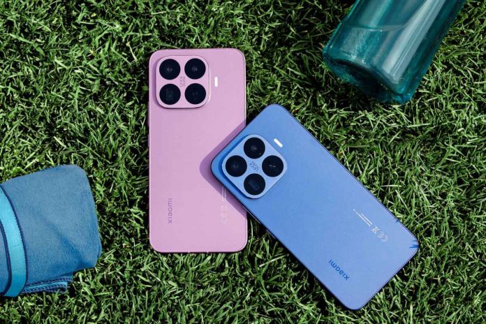 Du išmanieji telefonai ant vejos Du Xiaomi išmanieji telefonai guli ant žalios vejos šalia mėlynos rankšluosčio dalies ir mėlynos stiklinės butelio