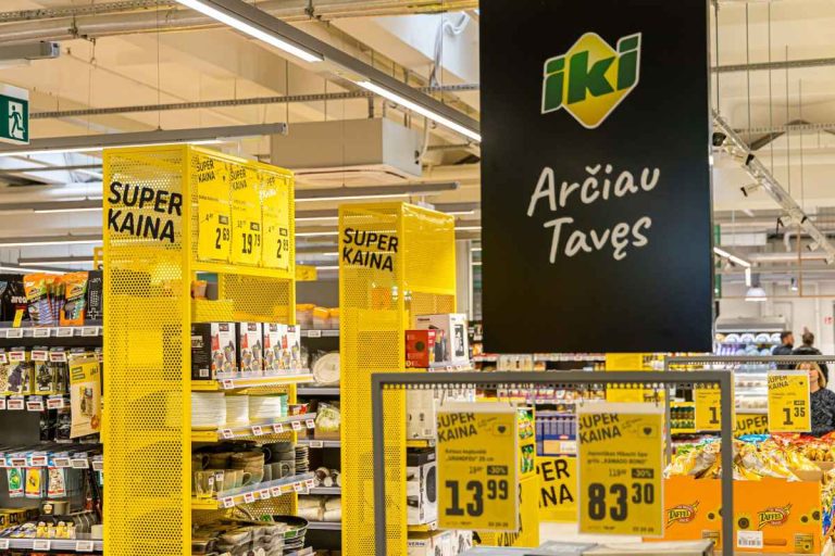 Prekių lentynos su kainų ženklais viduje parduotuvės.